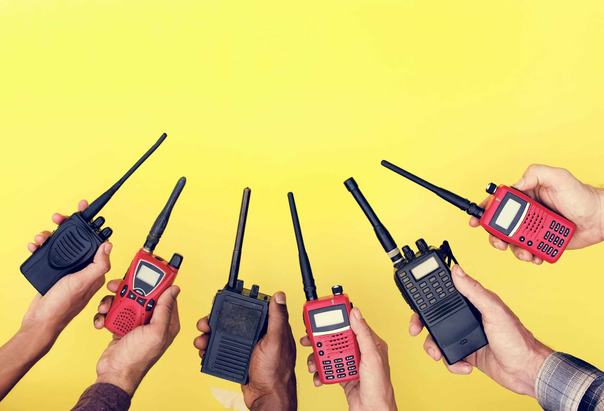 group of hands holding portable two way radios PAKCLZ